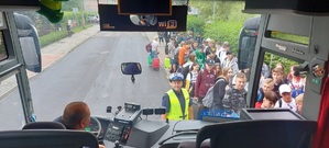 zdjęcie zrobione z wnętrza autokary, pred autobusem stoi policjant