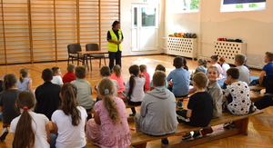 policjantka na spotkaniu z dziećmi rozmawia z grupą na sali gimnastycznej