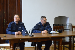 dwóch umundurowanych policjantów siedzących przy stole