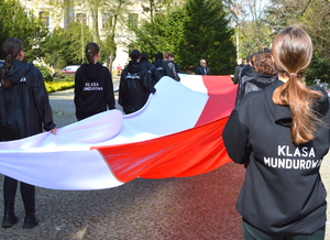 uczniowie klasy mundurowej trzymający flagę Polski