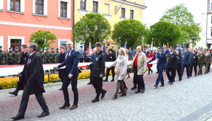 komendant oraz inne osoby trzymający flage