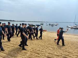 policjanci idący po piasku na plaży