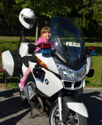 dziecko siedzące na policyjnym motocyklu