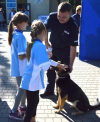 dzieci głaszczące policyjnego psa