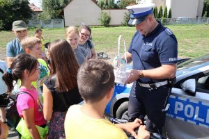 policjant rozdający upominki dla dzieci