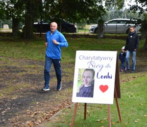 uczestnicy biegu , biegnący po bieżni wokół boiska