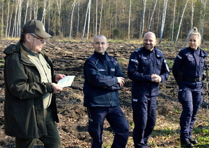 trzech umundurowanych policjantów stojących w miejscu gdzie będzie sadzony las