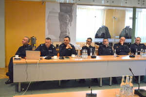 sześciu policjantów siedzących przy stole