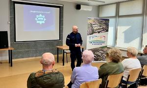 umundurowany policjant stojący przodem do widowni podczas przemowy