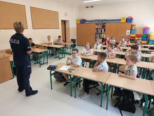 policjantka podczas prowadzonej prelekcji w tle siedzące dzieci