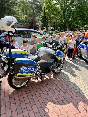 dzieci na zewnątrz oglądają policyjny motocykl
