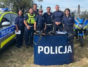 Policjanci przy radiowozie i motocyklu