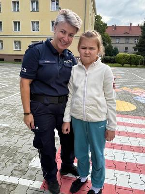 policjantka z dzieckiem stojąc na placu