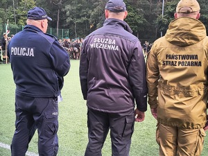 Policjant, strażak i funkcjonariusz zakładu karnego stojący tyłem