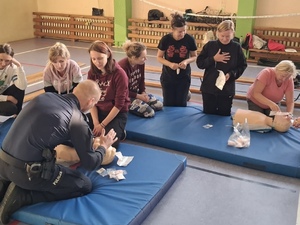 kobiety na macie przysłuchujące się policjantowi