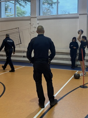 rzut piłką przez uczennicę i policjanci oceniający