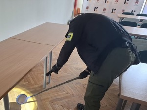policjant  w budynku przeszukujący teren