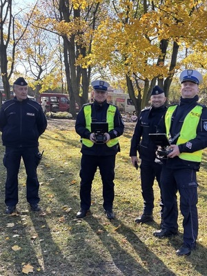policjanci z dronem służbowym przy cmentarzu