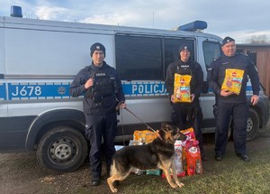 policjanci przy radiowozie z karmą i psem Atosem