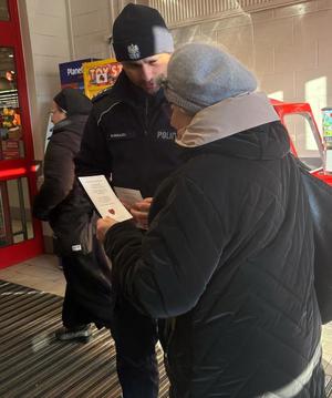 policjant rozdający kartki