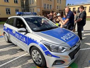 dzieci z przy aucie z policjantem