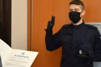 policjant stoi z podniesiona prawą ręką wypowiadając słowa roty ślubowania.