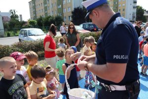 policjant rozdający upominki dla dzieci